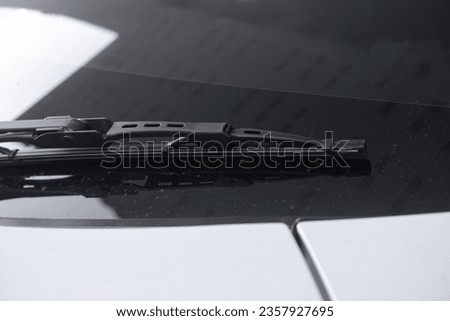 Photograph of windshield wipers on a white car