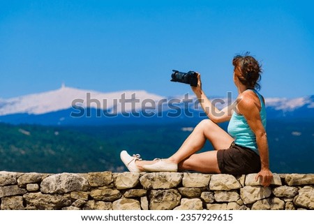 Tourist mature woman take travel picture from mountain landscape in Provence France. Mount Ventoux on horizon.