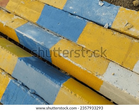 Rectangular concrete with painted color red, yellow. Construction material. Concrete or cement in construction site. Gray rectangular rough concrete texture background