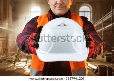 White hardhat in builder hand. Protective helmet for worker head. Foreman recommends wearing hardhat. Master in renovated room. Construction safety equipment. Cropped foreman with hardhat Royalty-Free Stock Photo #2357941205
