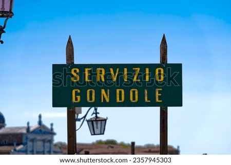 Old town of Italian City of Venice with green sign with golden letters at gondola pier at Piazza San Marco square on a sunny summer day. Photo taken August 7th, 2023, Venice, Italy.