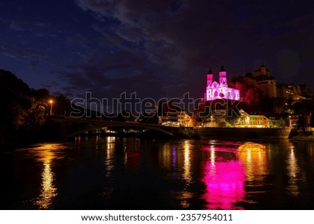 night picture of the - completely illuminated in pink - reformed church of Aarburg, Switzerland