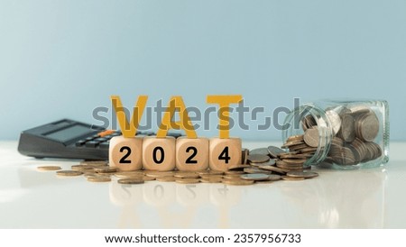 VAT in 2024 concept. VAT wooden letter and 2024 number on wooden block and glass coin jar with  calculator. Value Added Tax. Royalty-Free Stock Photo #2357956733