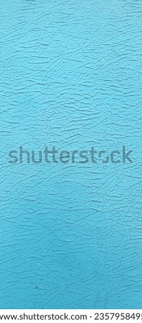 Portrait of tear ripped damaged synthetic leather blue sofa. Aging old cracked damaged leather on sofa synthetic leather upholstery. Long banner abstract texture background. Furniture