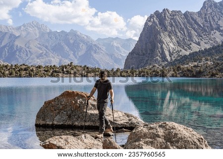 Man hiker exploring mountains lake in Tajikistan. High quality photo