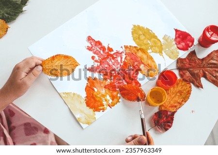 Children's autumn activity, leaf print on paper.