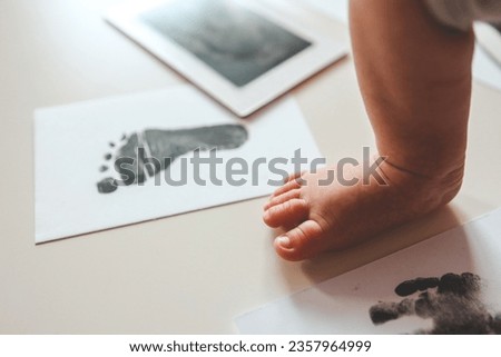 Baby footprints on white paper. Black footprint. The process of creating a baby footprint.