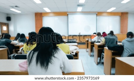 Education, teaching, learning concept. Rear view of college students listen to teacher teaching and explaining lesson in classroom Royalty-Free Stock Photo #2357973169