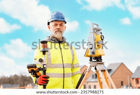 Surveyor builder site engineer with theodolite total station at construction site outdoors during surveying work Royalty-Free Stock Photo #2357988271