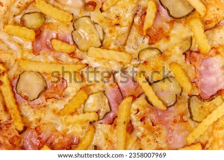 Background with close-up pizza with bacon, cucumbers, fries and cheese.