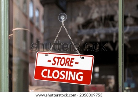 Close-up on a red sign in a window written inside in English "Store closing".