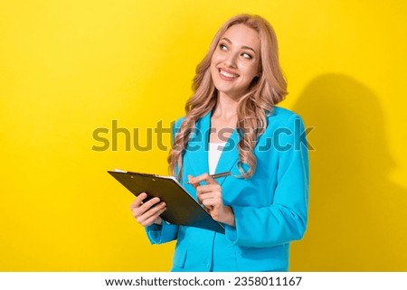 Photo of classy pretty corporate girl hold clipboard pen look empty space isolated on yellow color background Royalty-Free Stock Photo #2358011167