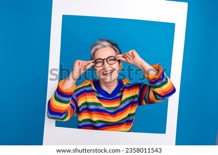 Portrait of cool positive person hands touch eyeglasses inside paper album set card isolated on blue color background Royalty-Free Stock Photo #2358011543