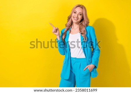 Photo of stunning cheerful lady direct finger empty space ad blank information isolated on yellow color background