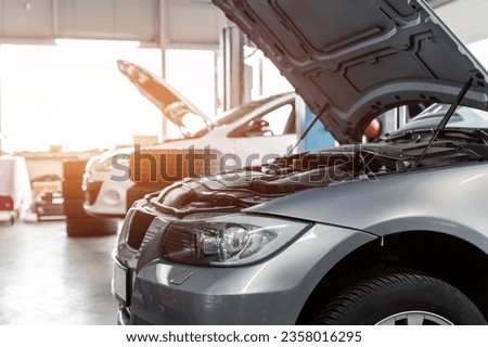 Car service center garage workshop. Vehicle raised on lift at maintenance station. Automobile repair and check up. Automotive insurance and technical checkup inspection diagnostic Royalty-Free Stock Photo #2358016295