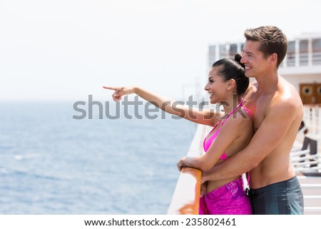 romantic couple on cruise pointing at ocean