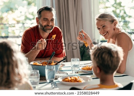 Shot of beautiful kind family talking while eating together in the kitchen at home Royalty-Free Stock Photo #2358028449