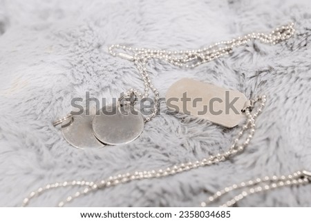 Blank military dog tags on abandoned metal plate. Memories and sacrifices concept. Still life disc necklace. Image for e-commerce, online selling, social media, jewelry sale.