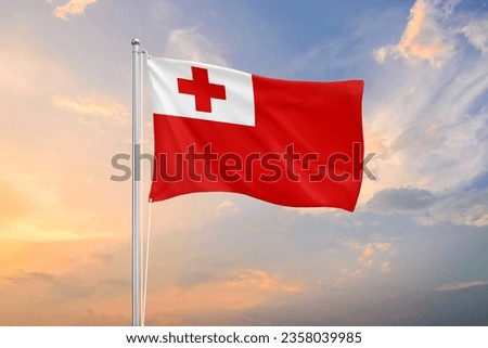 Tonga flag waving on sundown sky Royalty-Free Stock Photo #2358039985