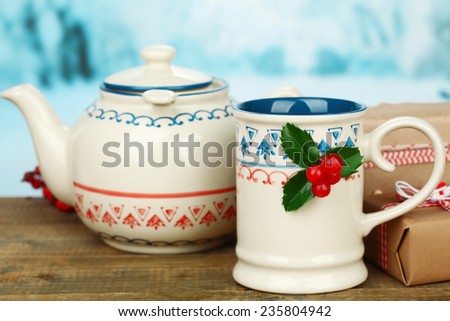 Christmas composition with cup and teapot of hot drink, on wooden table