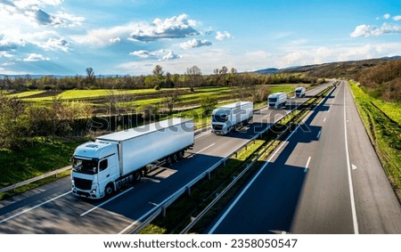 Convoy of white Trucks with containers on highway, cargo transportation concept in springtime - freight service Royalty-Free Stock Photo #2358050547
