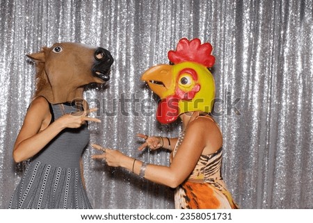 Photo Booth. Two people wear Animal Head Masks and pose for pictures while in a Photo Booth. Photo Booths are popular at all parties and events. Everyone loves Photo Booth Pictures. Horsing around. 