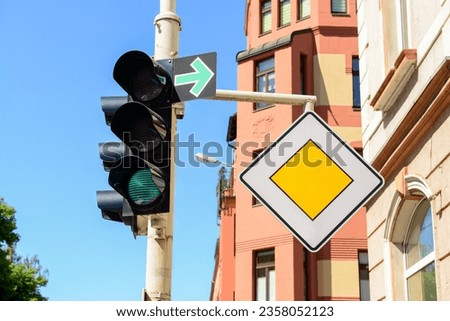 View of green traffic light with road signs in city, closeup