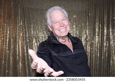 Photo Booth. A man Smiles and Poses while having his Picture Taken in a Photo Booth at a Wedding or Party. People world wide love a fun Photo Booth at Parties and Events. Picture Booth. Smile. Party.