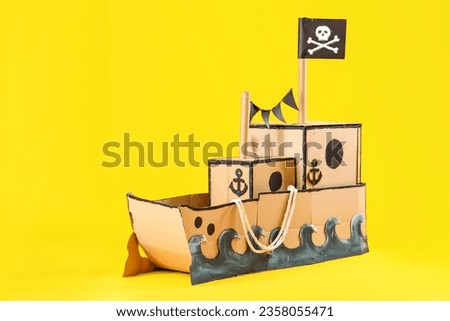 Pirate cardboard ship with rope on yellow background