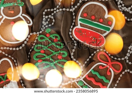 Banner for Christmas and New Year gingerbread. Christmas trees, toys, snowmen, garlands on a background of brown silk fabric. Bright bokeh