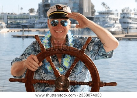 Photo Booth. Yacht. A man poses for pictures while in a Photo Booth on a Yacht at a Party. Everyone loves a Photo Booth even on Yachts and Pleasure Boats. Captain Spike on his Pleasure Boat. Smile. 