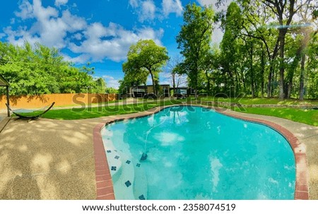 Residential backyard with inground pool, tall trees and vibrant landscape in Texas DFW area Royalty-Free Stock Photo #2358074519