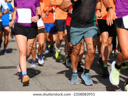 legs of male and female runners with sneakers running during city marathon Royalty-Free Stock Photo #2358083951