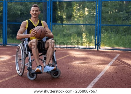 Young man in wheelchair playing basketball outdoor.
