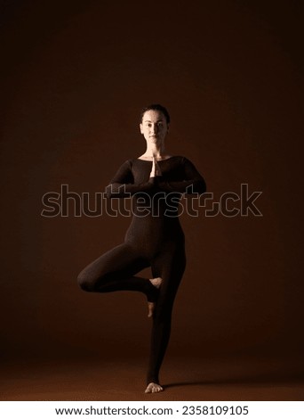 portrait of a woman in yoga poses on a brown background.a woman professionally demonstrates yoga poses and gestures in brown sportswear on a brown background