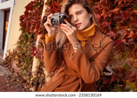 Closeup shot of pretty young woman, photo enthusiast photographing with analog, film camera