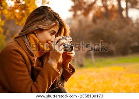 Closeup shot of pretty young woman, photo enthusiast photographing with analog, film camera