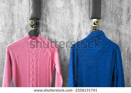 Two turtlenecks hang on hanger in the fitting room pink, blue cheap synthetics, outdated model, past collection Shopping, choosing clothes, color Gender stereotypes Collection of bright women clothing