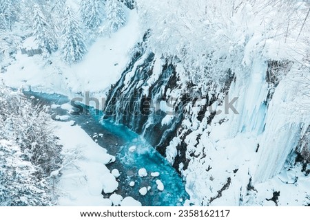Shirahige Waterfall with Snow in winter, Biei river flow into Blue Pond. landmark and popular for attractions in Hokkaido, Japan. Travel and Vacation concept Royalty-Free Stock Photo #2358162117