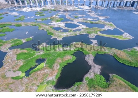 Aerial footage of the River Bhima and surrounding landscape including bridges at Daund India. Royalty-Free Stock Photo #2358179289