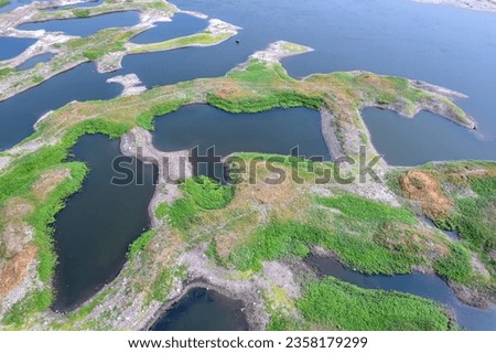 Aerial footage of the River Bhima and surrounding landscape including bridges at Daund India. Royalty-Free Stock Photo #2358179299