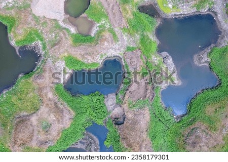 Aerial footage of the River Bhima and surrounding landscape including bridges at Daund India. Royalty-Free Stock Photo #2358179301