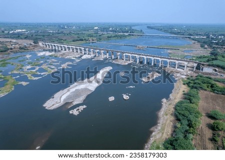 Aerial footage of the River Bhima and surrounding landscape including bridges at Daund India. Royalty-Free Stock Photo #2358179303