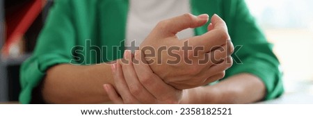 Close-up of woman office worker touching sore wrist from using computer. Carpal tunnel syndrome. Arthritis office. Healthcare and medicine concept
