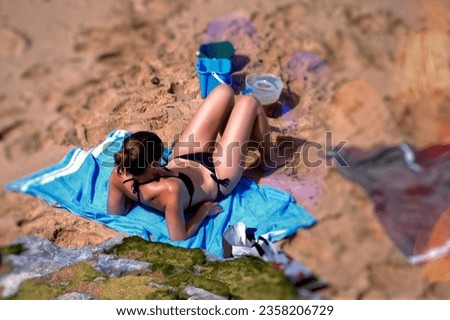 Young woman in a bikini lying on the sand at the beach