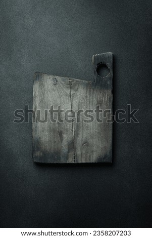 Kitchen vintage wooden cutting board. Brown board. Kitchen utensils. On a dark background.