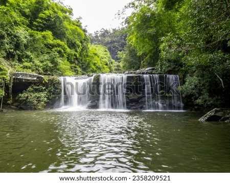 Huai Luang waterfall, Waterfall middle of the humid forest at Ubon Ratchathani, Thailand, Asia. Leaf moving low-speed shutter blur.