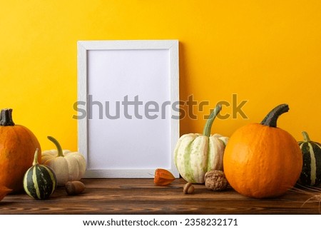 Thanksgiving Crop Exhibition. Side view picture showcasing empty photo frame and abundant harvest arrangement on rustic wooden table, set against orange wall background, with space for text or advert