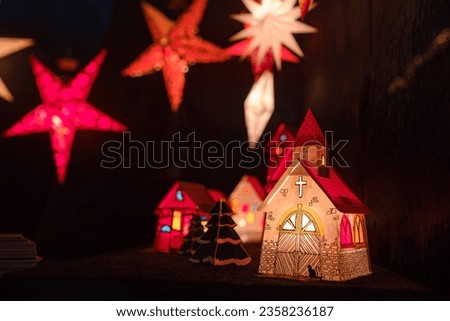Essen, Germany - December 13, 2022: Christmas atmosphere at the open xmas market. Celebrating Xmas holidays. Lights, carousel, small houses, toys and decorations at fair in European city or town