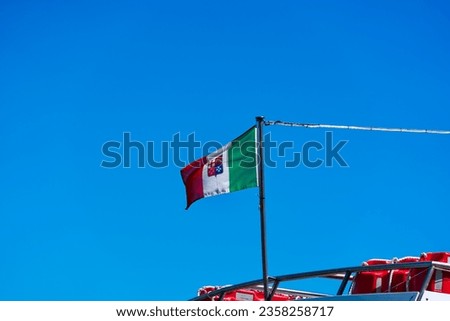 Italian flag waving on board of passenger ship at San Giorgio Canal at City of Venice on a sunny summer day. Photo taken August 7th, 2023, Venice, Italy.